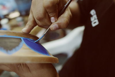 Close-up of hand painting earthenware