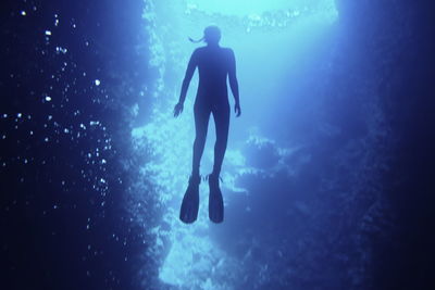 Low angle view of silhouette person swimming in sea