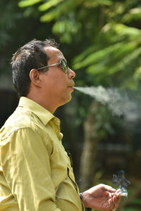 Close-up of man smoking cigarette outdoors