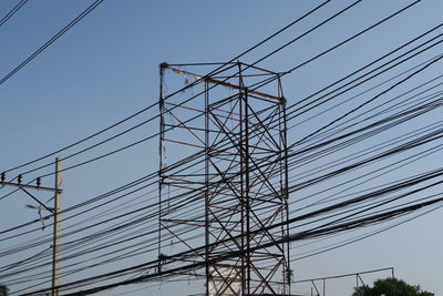 Low angle view of electricity pylon against clear sky