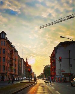 Road by street against sky during sunset