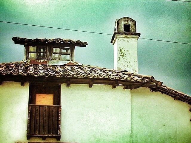 architecture, building exterior, built structure, low angle view, church, place of worship, religion, sky, house, spirituality, window, cross, high section, blue, roof, outdoors, day, door