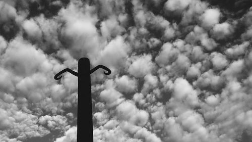 Low angle view of street light against cloudy sky