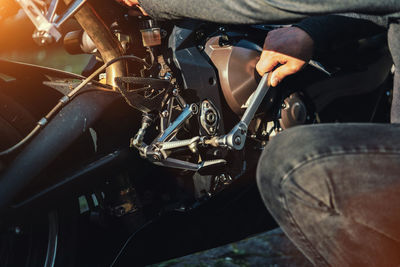 Midsection of mechanic repairing motorcycle