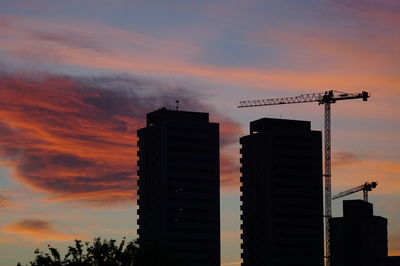 Low angle view of silhouette crane against sky during sunset