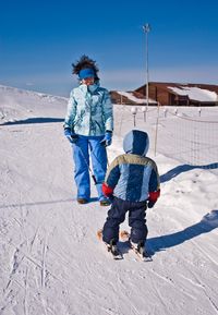 Girl instructor teaches the basics of skiing to a child