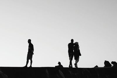 Silhouette people standing against clear sky