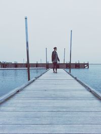 Full length of woman standing on pier against sky