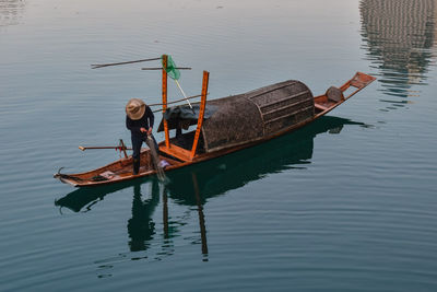 High angle view of man on fishing boat in lake