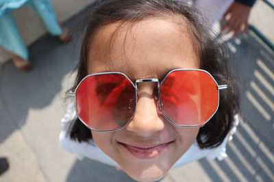 High angle close up portrait of a smiling girl with sunglasses