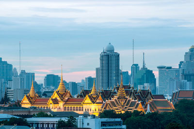 Buildings in city against cloudy sky