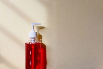 Close-up of red bottles against wall