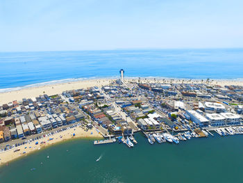 High angle view of cityscape by sea against sky