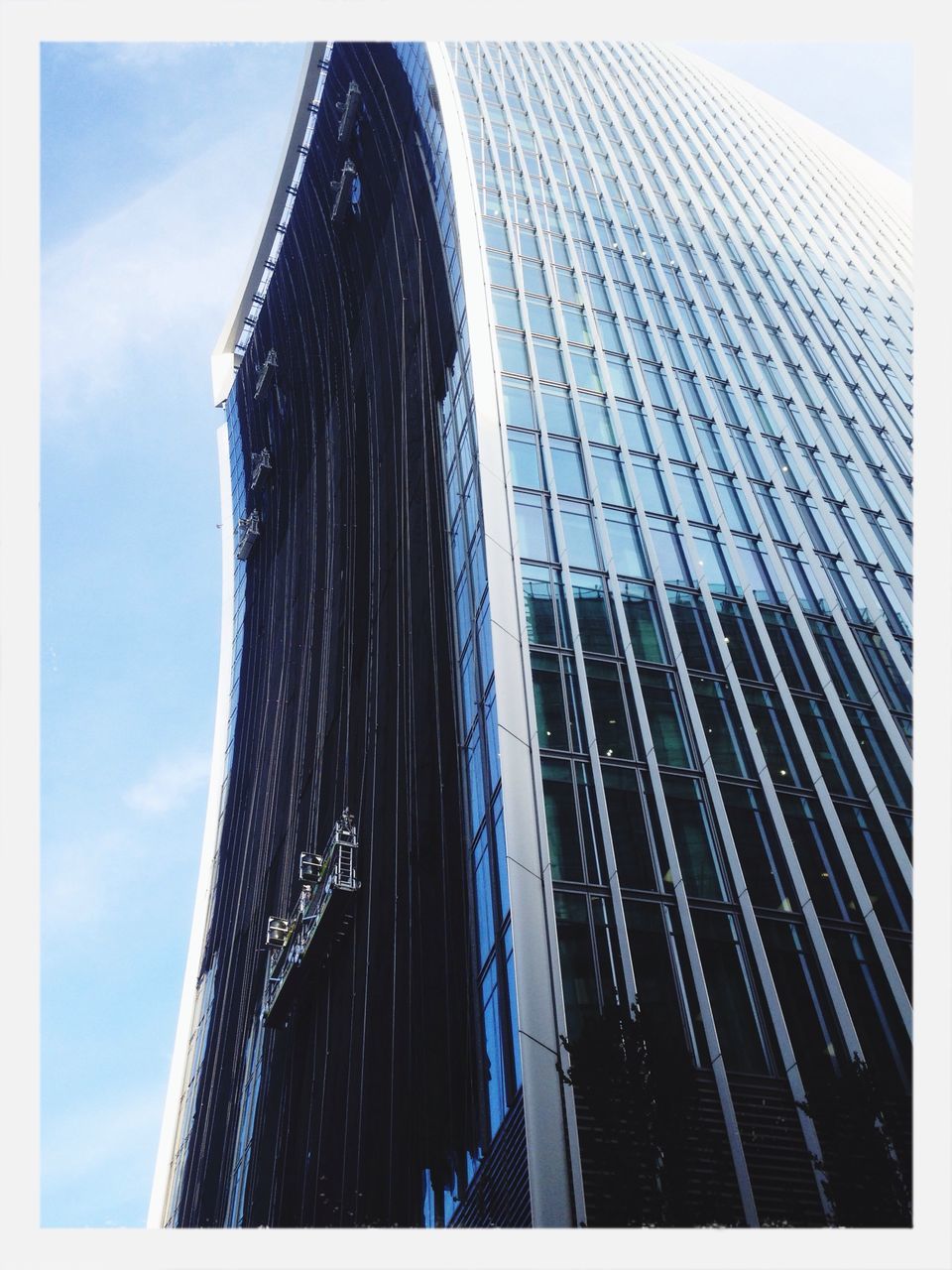 low angle view, transfer print, built structure, sky, architecture, auto post production filter, building exterior, tall - high, modern, skyscraper, day, city, outdoors, no people, office building, pattern, cloud - sky, sunlight, tower, tilt