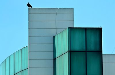 Low angle view of buildings against clear blue sky