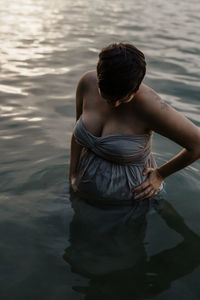 Rear view of woman standing in lake