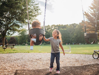 Full length of siblings playing at park