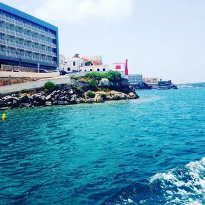 Calm sea with buildings in background