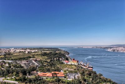 High angle view of town by sea against clear sky