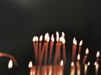 Close-up of lit candles against black background