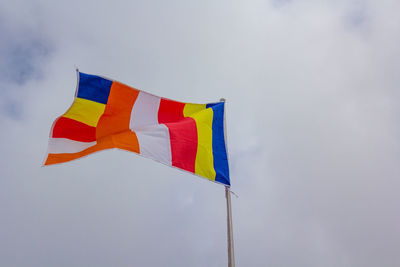 Low angle view of flag against blue sky