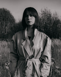 Portrait of a young woman standing on field