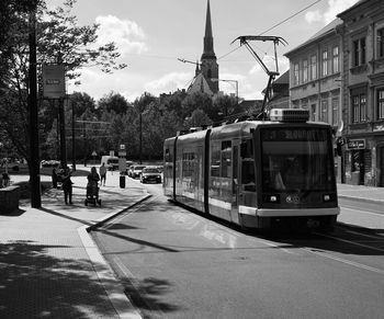 Man on bus in city against sky