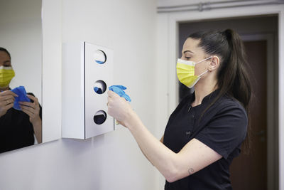 Female dentist holding protective face mask