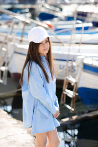 Portrait of young woman standing against sky