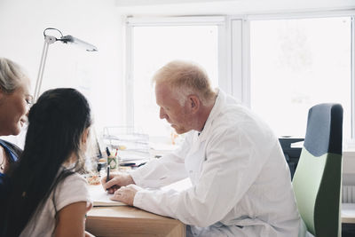 Side view of couple sitting on table