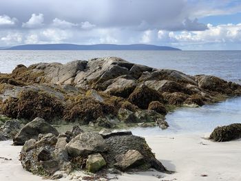 Panoramic view of rocks on beach against sky