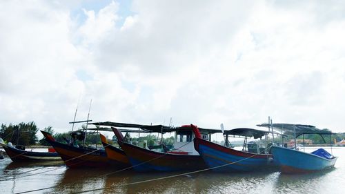 Boats moored on sea against sky