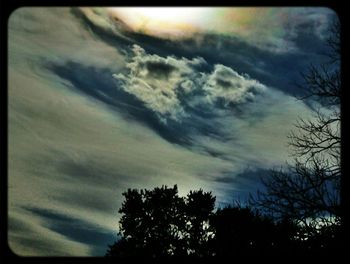 Silhouette of trees against cloudy sky
