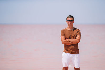 Portrait of man wearing sunglasses standing against sky