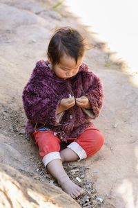 High angle view of girl sitting outdoors