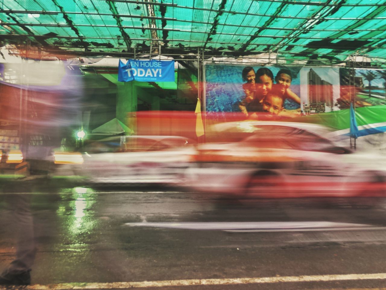 text, transportation, western script, communication, built structure, architecture, graffiti, information sign, road, street, glass - material, city, mode of transport, blurred motion, transparent, building exterior, illuminated, public transportation, indoors, road marking