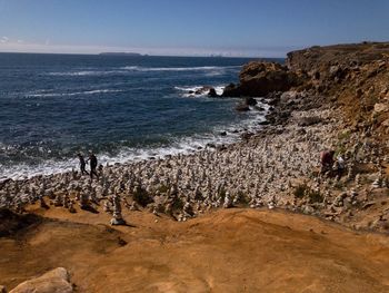 Scenic view of rocks on beach against sky