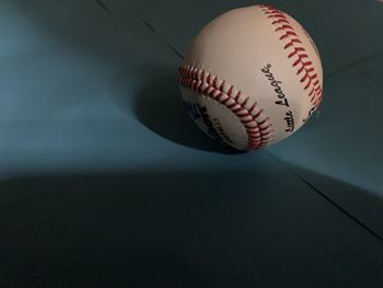 Close-up of baseball on blue background.