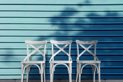 Empty chairs against blue wall