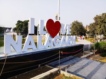 View of heart shape made from boat in canal against sky