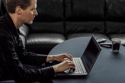 Man using mobile phone while sitting on sofa