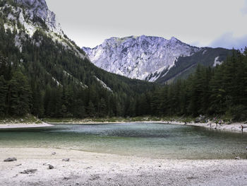 Scenic view of lake by mountains against sky