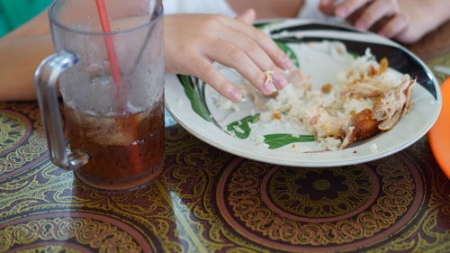 Midsection of woman having food on table