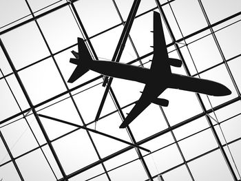 Low angle view of toy airplane hanging from glass ceiling at frankfurt airport