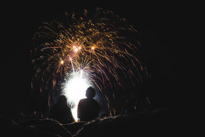 Low angle view of firework display at night