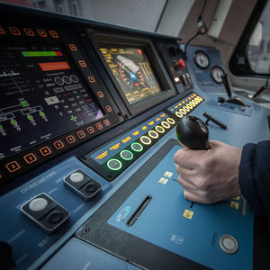 Cropped hand of pilot driving locomotive