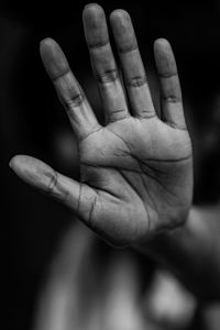 Close-up of human hand against black background