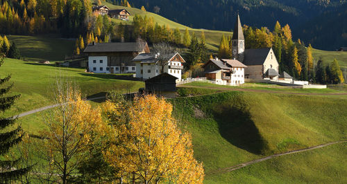 Houses by lake against buildings