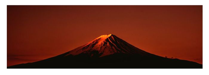 Panoramic view of snow covered mountain against sky during sunset