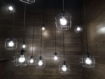 Low angle view of illuminated pendant lights hanging on ceiling